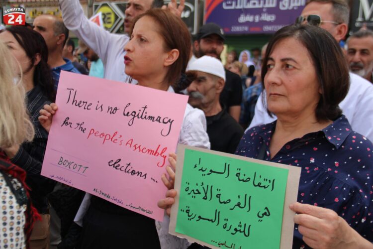 Protesters in Suwayda’s Al-Karamah Square call on Syrians to boycott the People’s Assembly elections. (Photo: Suwayda24)